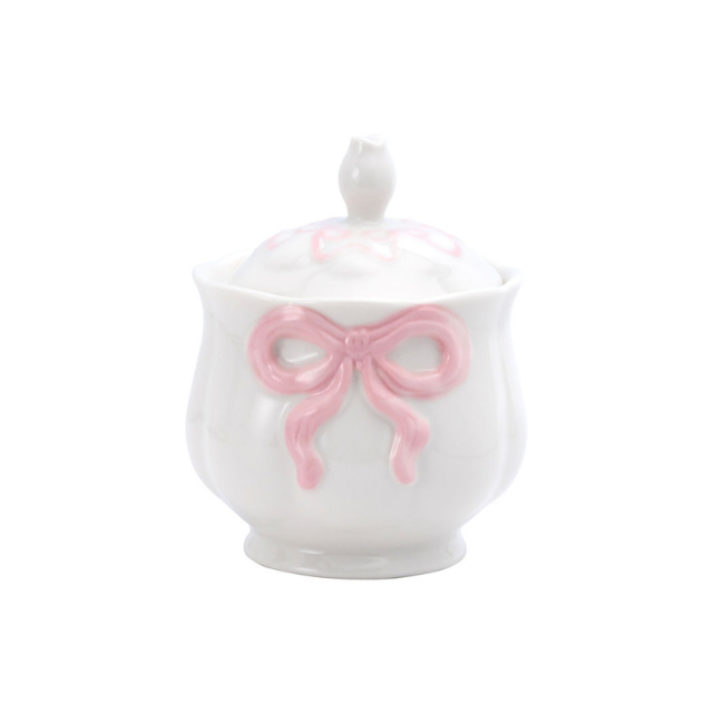 Delicate porcelain jar with a bow design on the front featuring a lid with a birdshaped handle