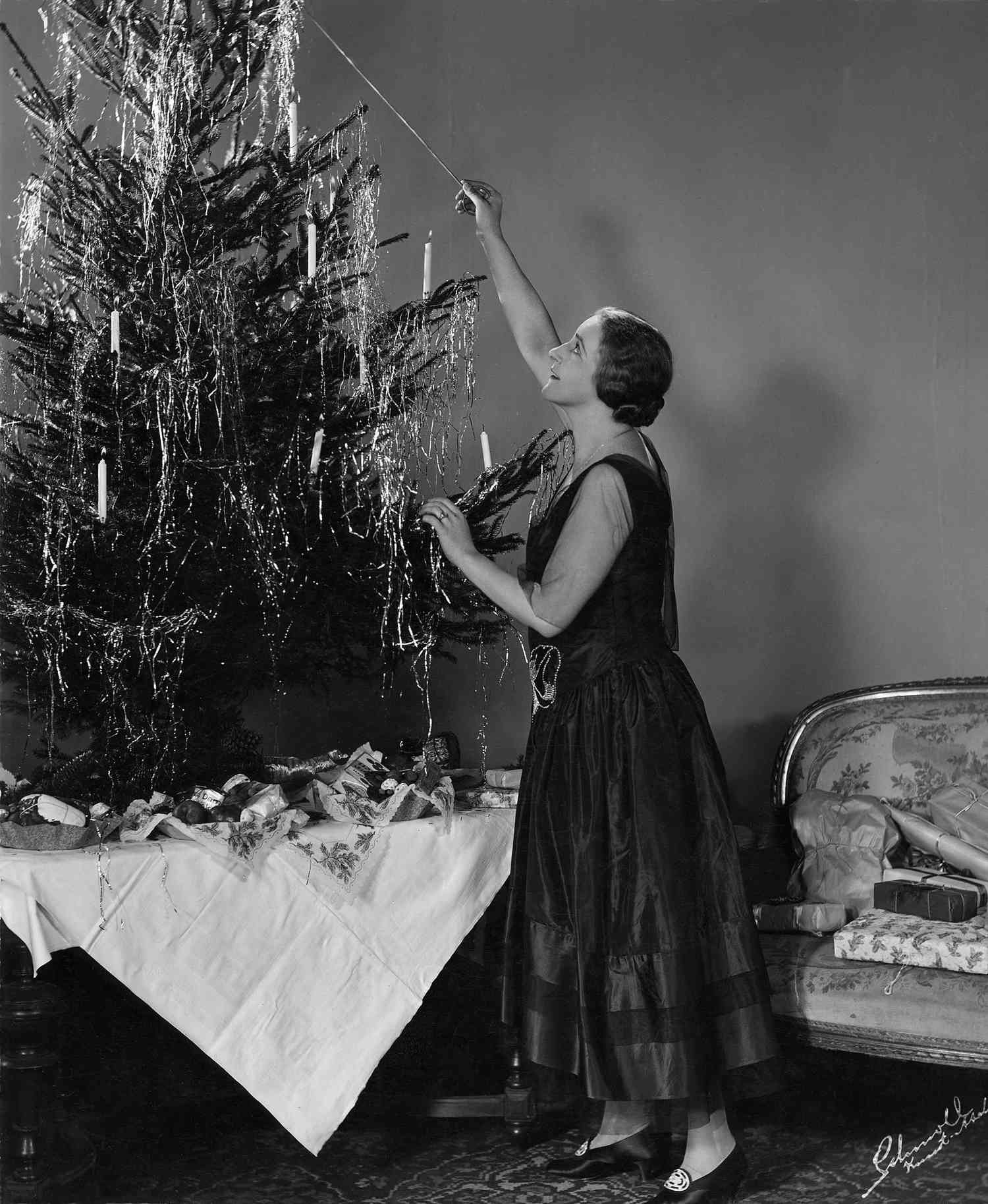 woman lighting a Christmas tree