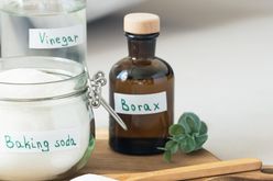 Containers of vinegar baking soda and borax on a countertop