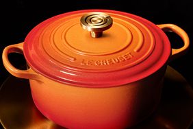 Le Creuset cast iron Dutch oven with lid and handles, brand logo engraved on top.