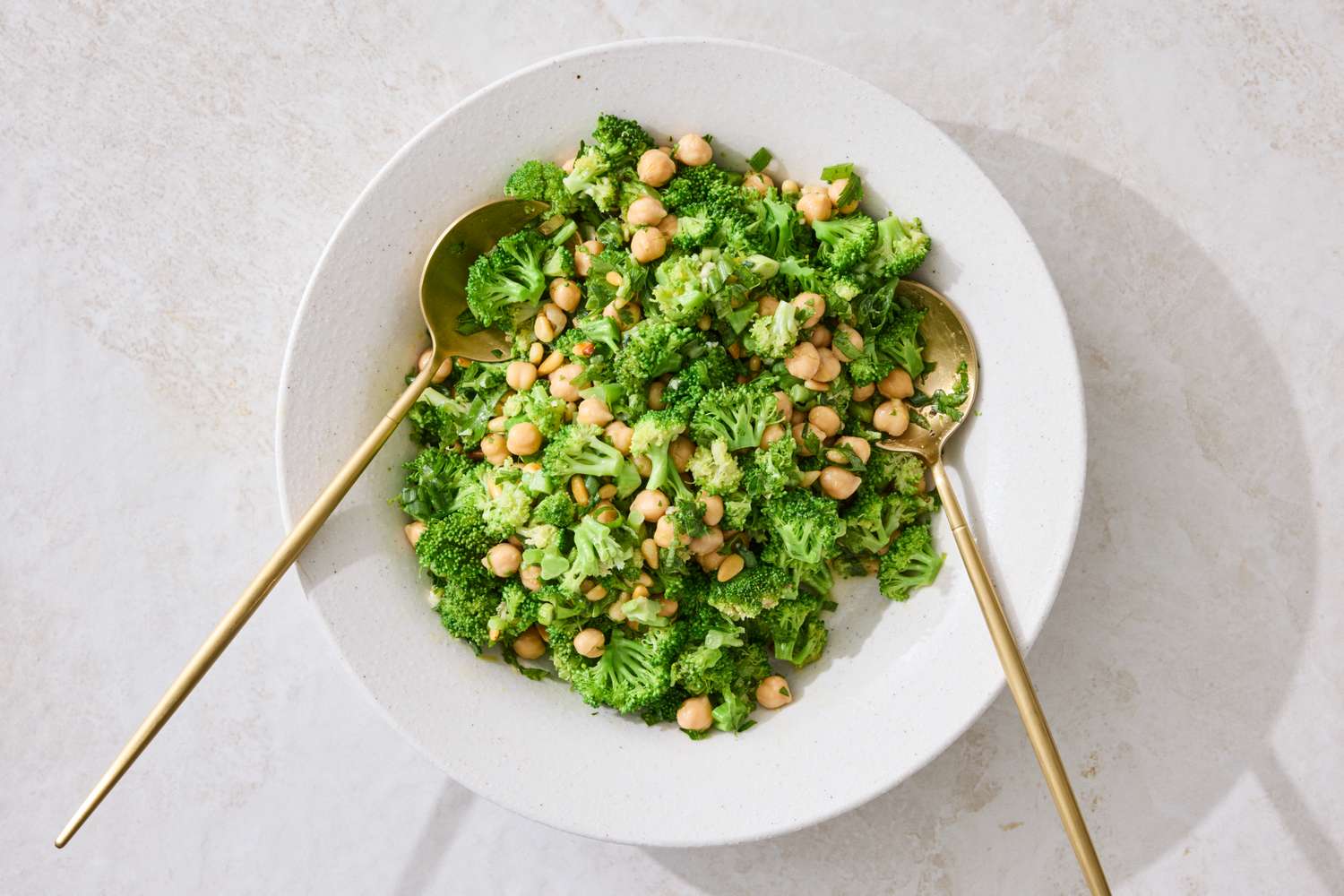Broccoli and chickpea salad served in a bowl with two spoons