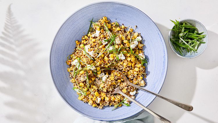 quinoa with caramelized corn and scallions served in a blue bowl