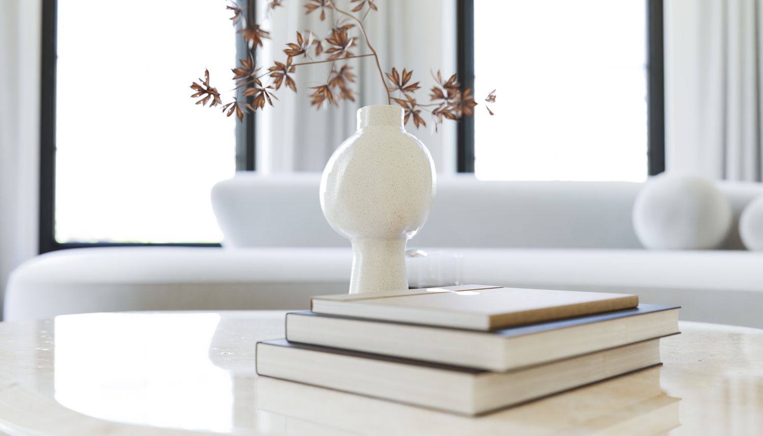 A small vase with decorative branches placed on a stack of books on a table