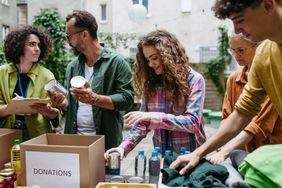 Group of people sorting and packing donations together outdoors