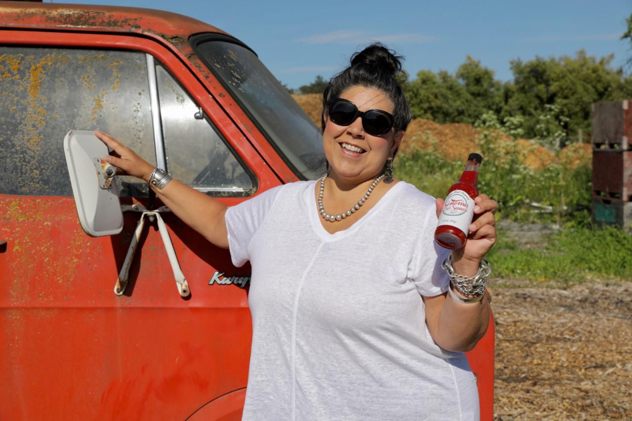 portrait of deb rock holding sonoma hot sauce bottle