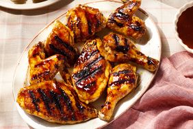 Platter with grilled barbecue chicken pieces on a table