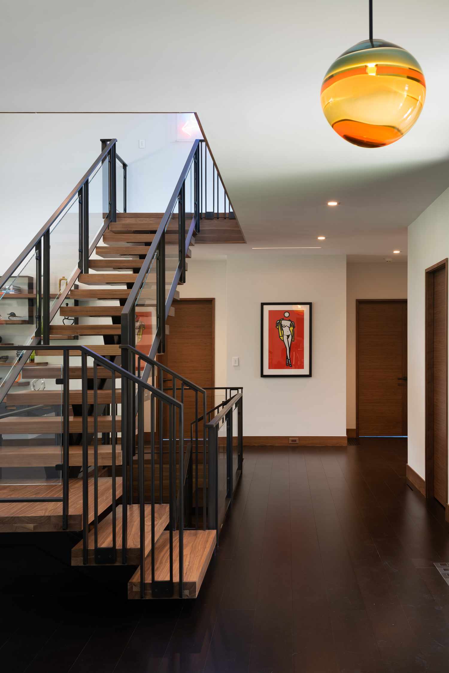 open wooden stair risers with glass and metal railings