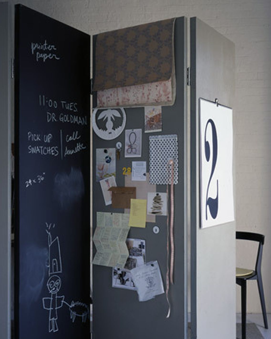 office room divider with notes and stationery pinned to the panels