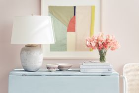 Lamp on table against wall with decor at home