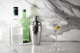 Gin cocktail with gin bottles in background