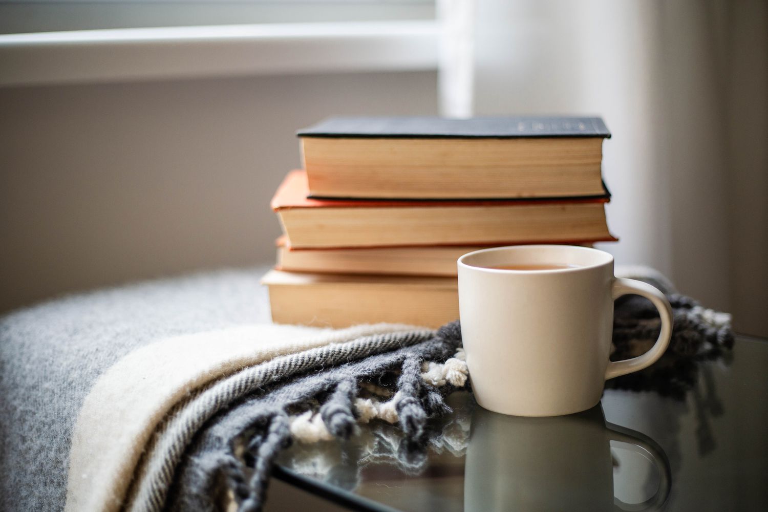 stack of books next to cup of tea