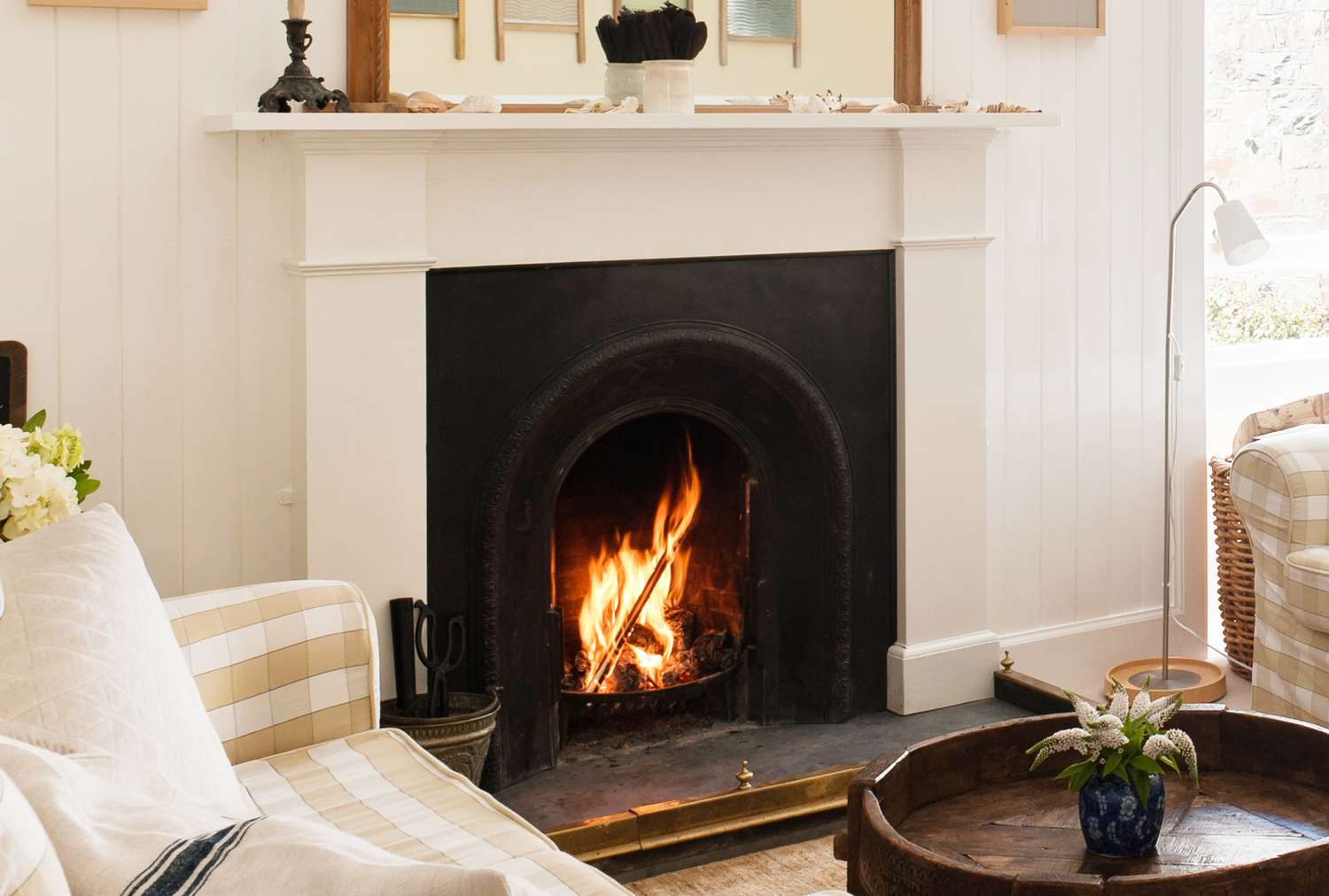 A cozy room with a lit fireplace surrounded by furniture and decor