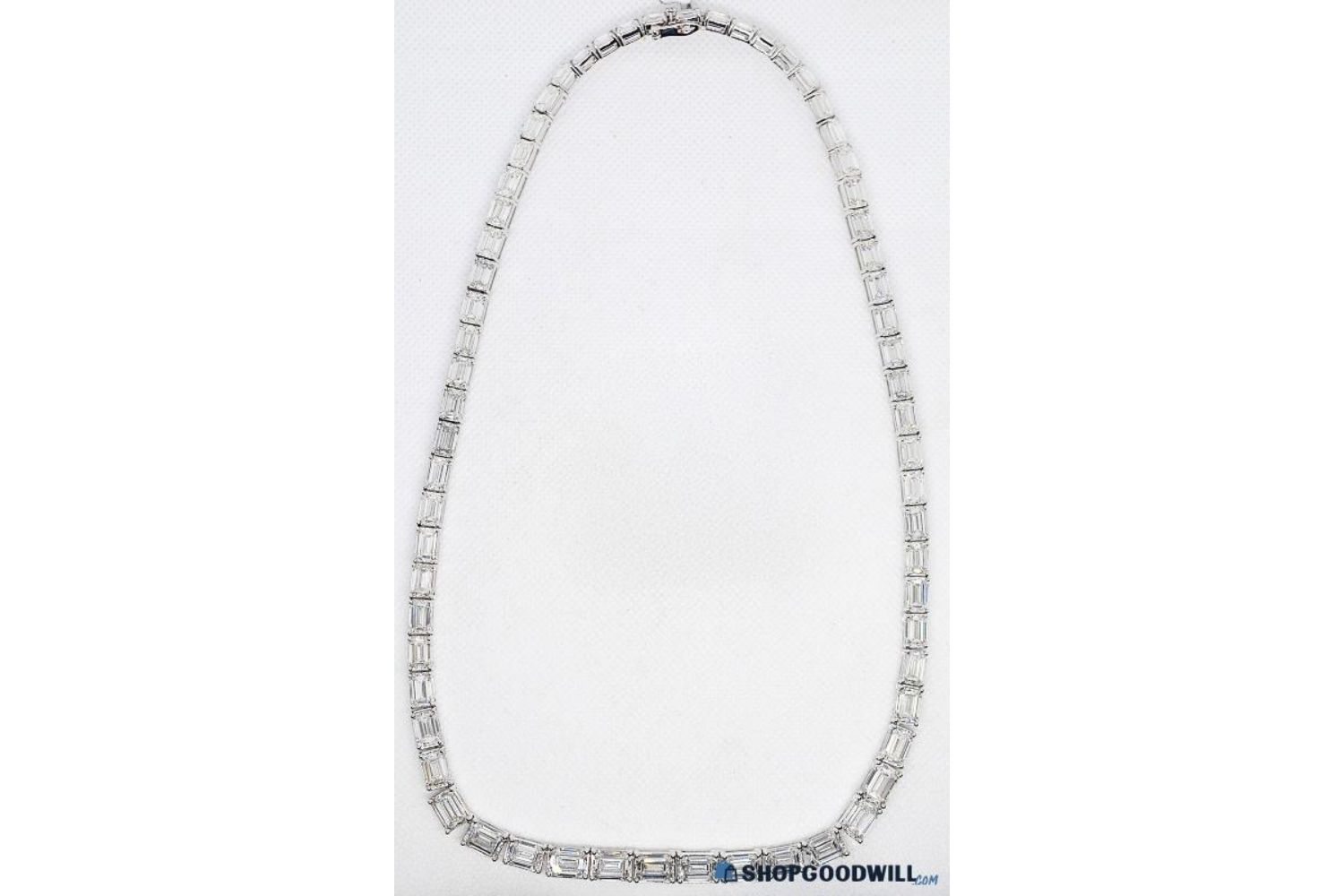 A diamond necklace displayed against a white background featuring linked gemstones in a continuous loop