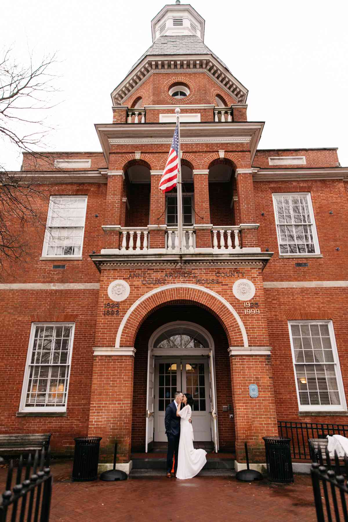 city hall wedding bride and groom kissing in front of red brick building