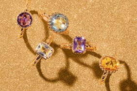 Assorted birthstone rings displayed on a textured surface