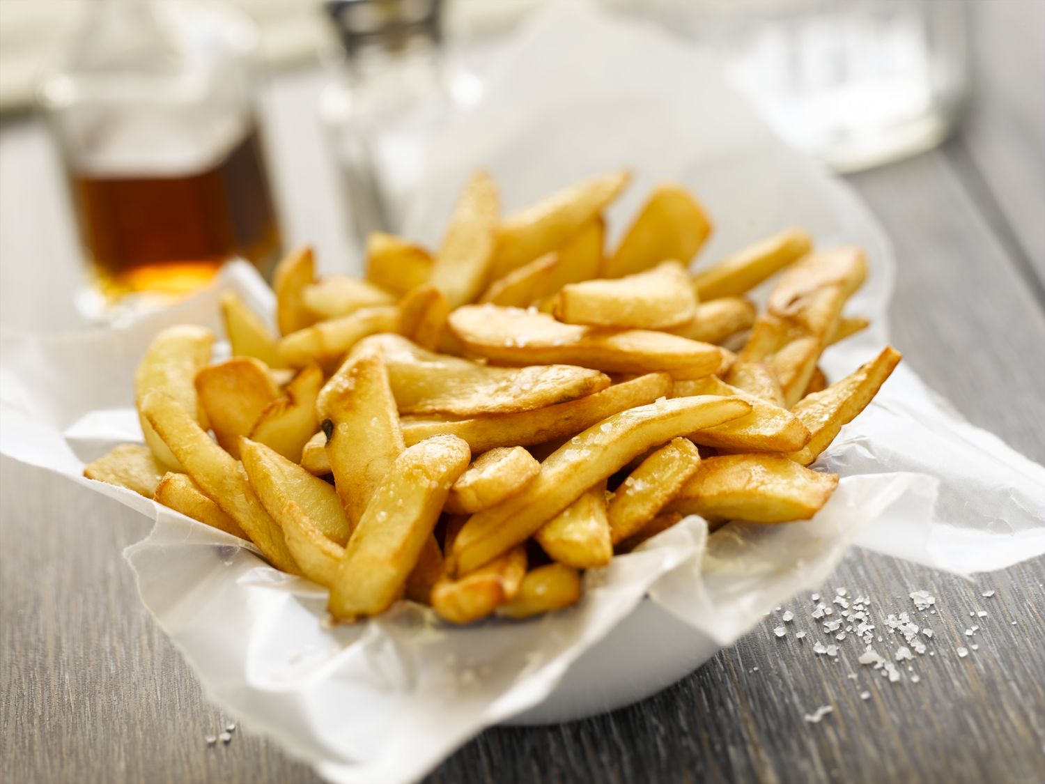 steak fries in wax paper lined dish on wooden surface