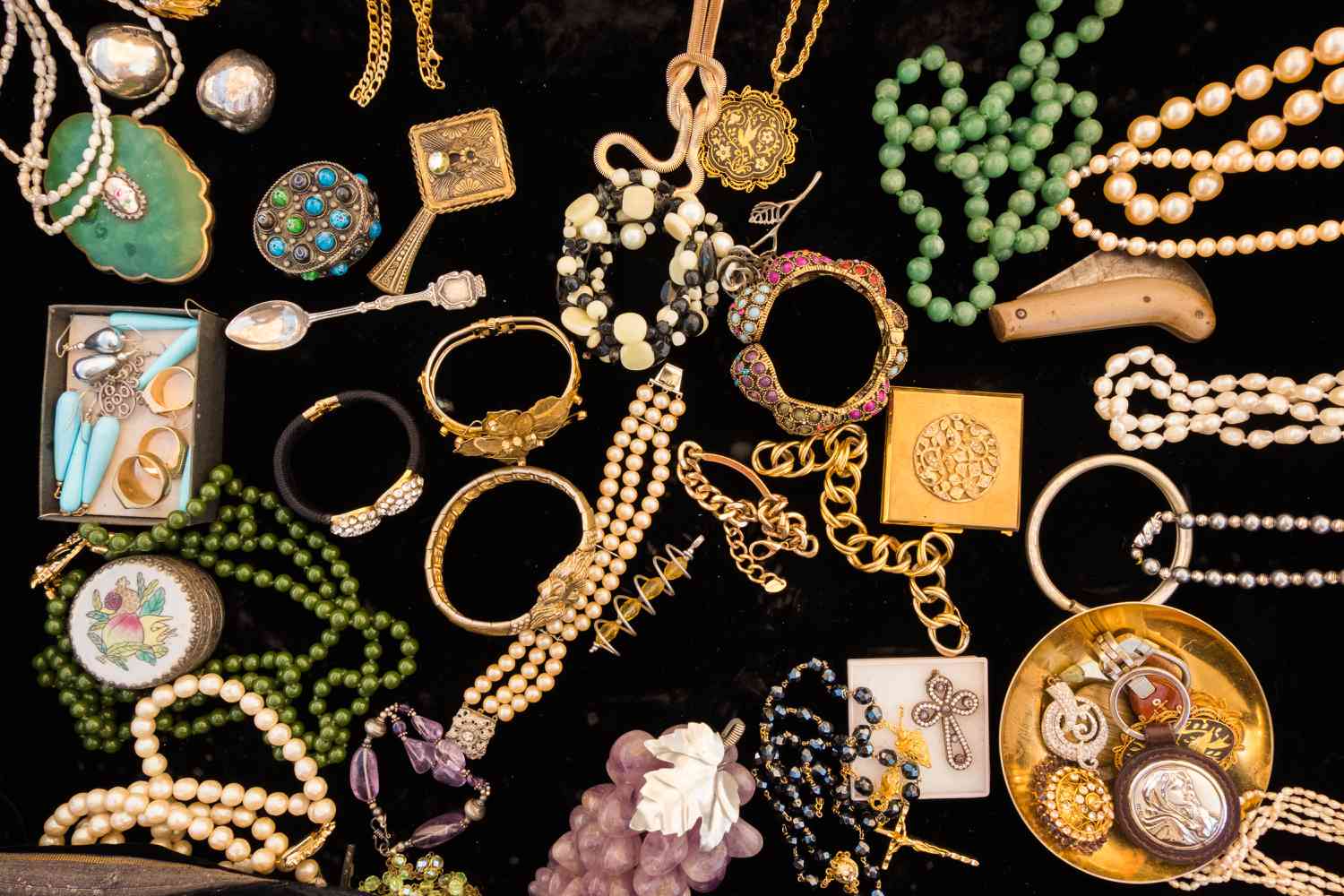colorful vintage jewelry scattered on black velvet