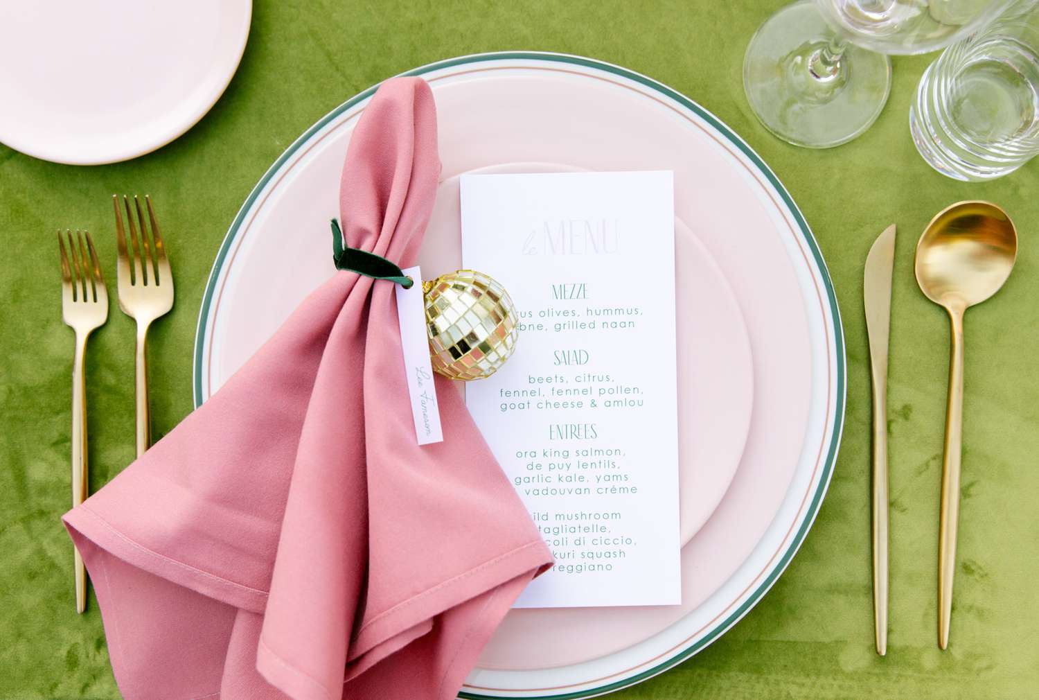 table arrangement with seating card pink plates and napkins with gold utensils