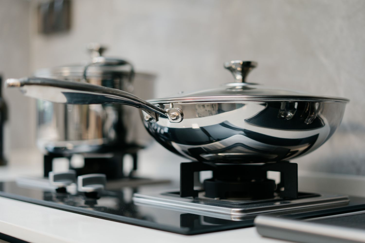 Two metal pots on a modern stovetop in a kitchen