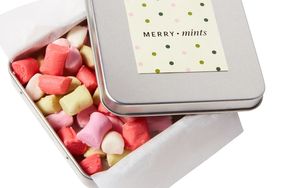 red pink and yellow butter mints in a tin box