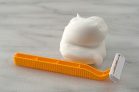 A razor and shaving cream on a surface