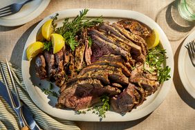 roast leg of lamb on a platter with garnishes