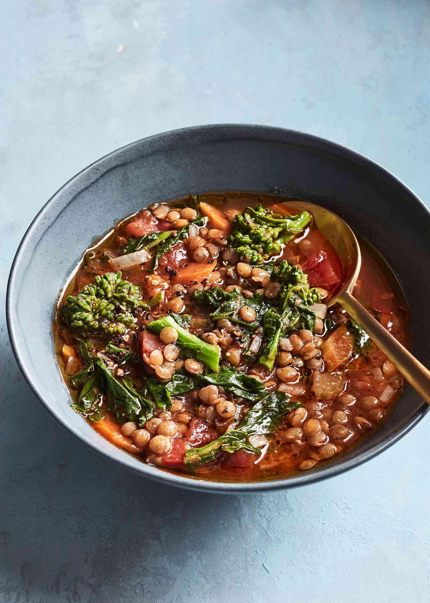 vegan lentil soup in bowl on blue table