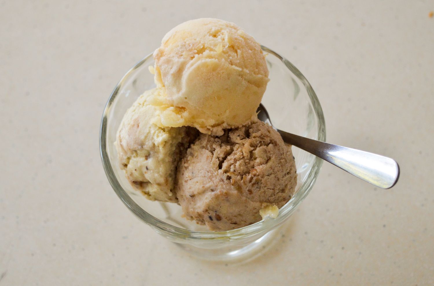 A bowl with three scoops of ice cream and a spoon