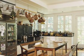 Rustic kitchen with hanging pots wooden table and benches