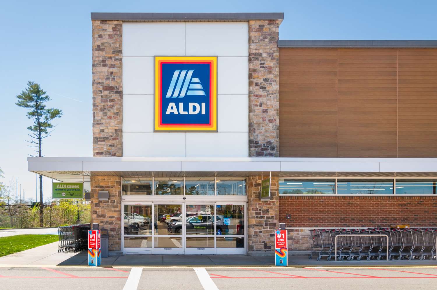 Front entrance of an Aldi store with shopping carts and signage displayed