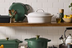 Various cookware items on kitchen shelves including Dutch ovens and a kettle