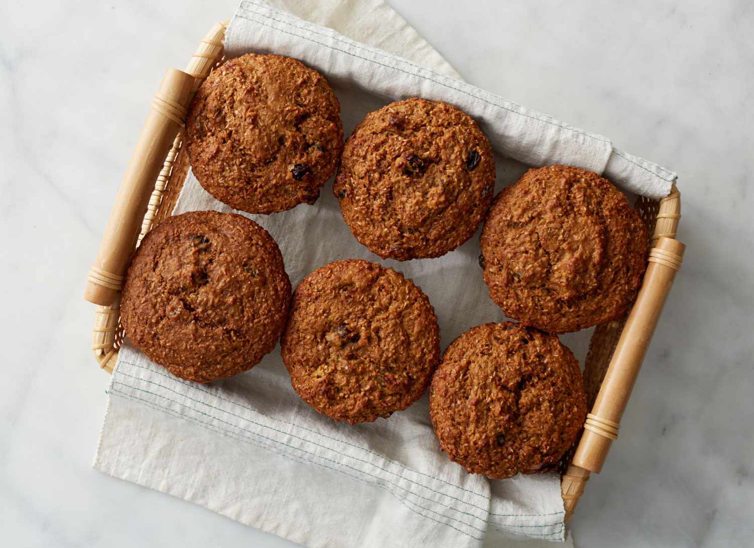 six bran and raisin muffins in a basket