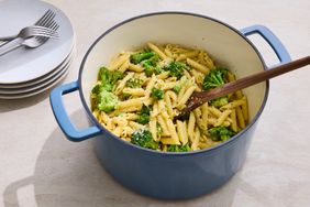 Pot filled with penne pasta and broccoli wooden spoon in the pot