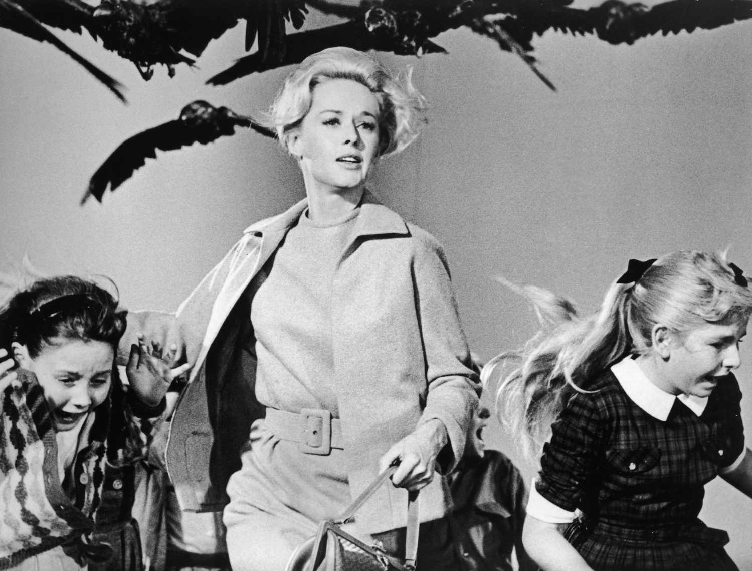 Tippi Hedren in a scene with birds flying overhead