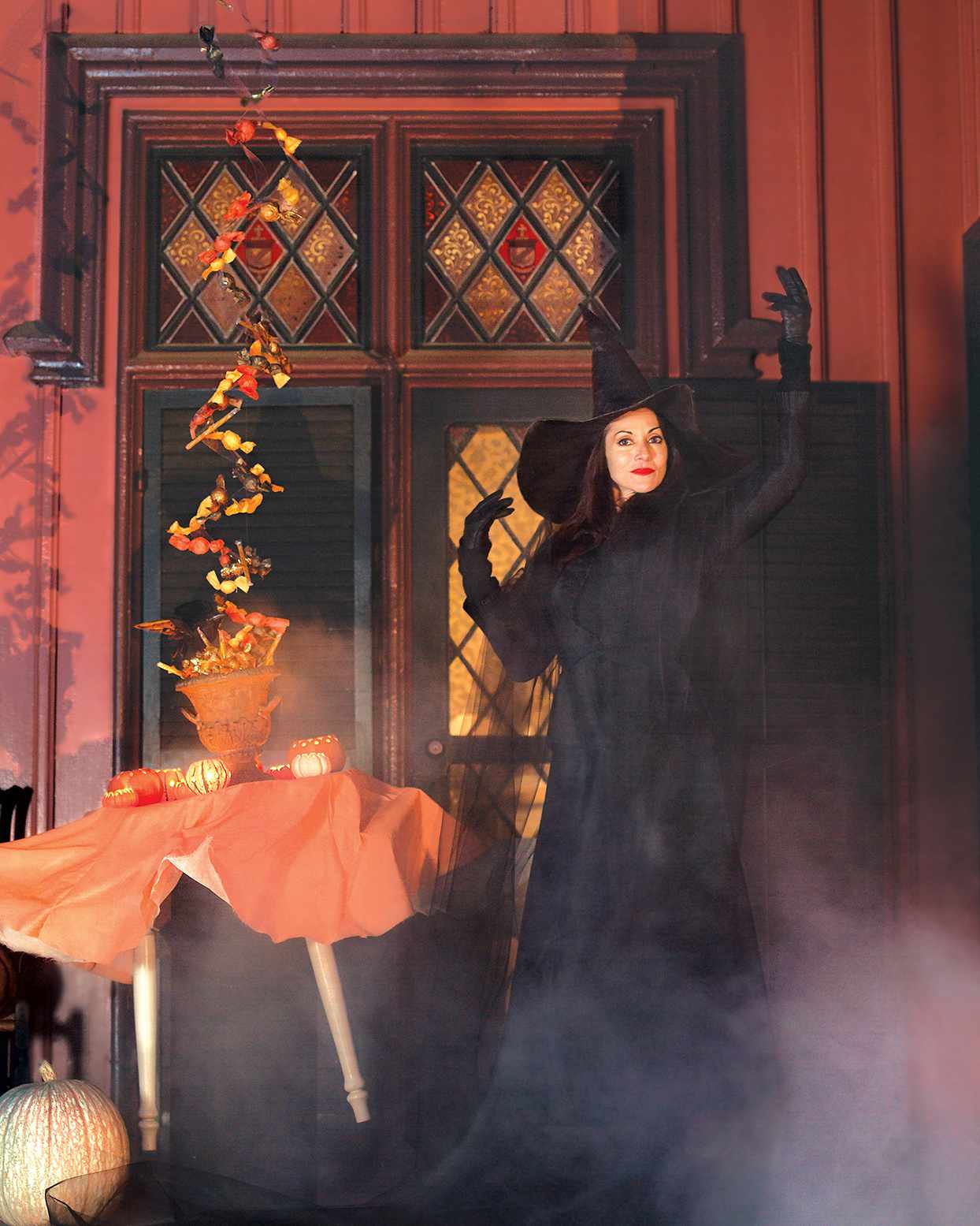 woman in witch costume next to levitating table