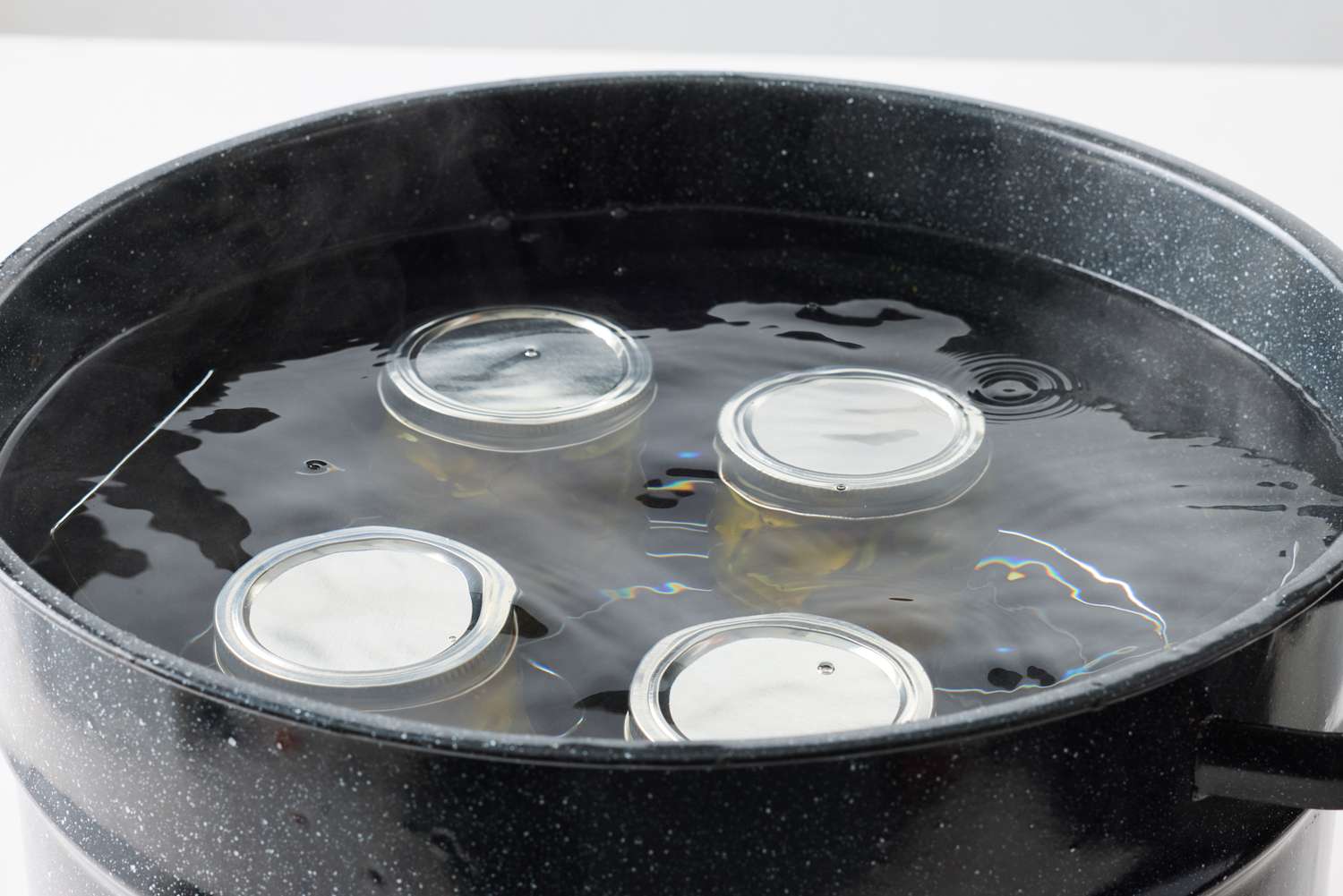 Canning jars covered in water inside a pot