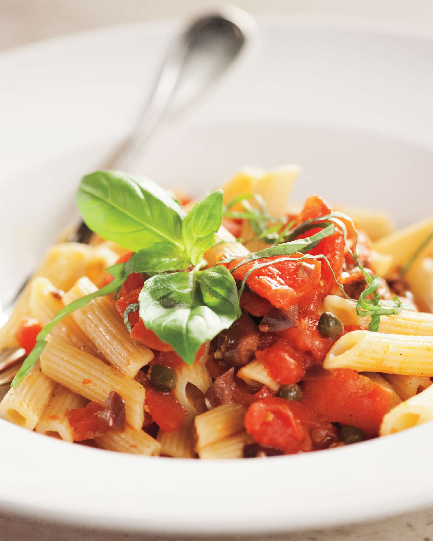 puttanesca pasta in white bowl