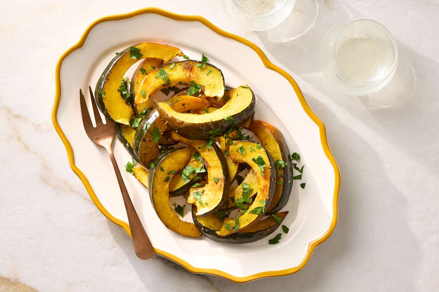 A serving of roasted spiced acorn squash on a platter with garnish