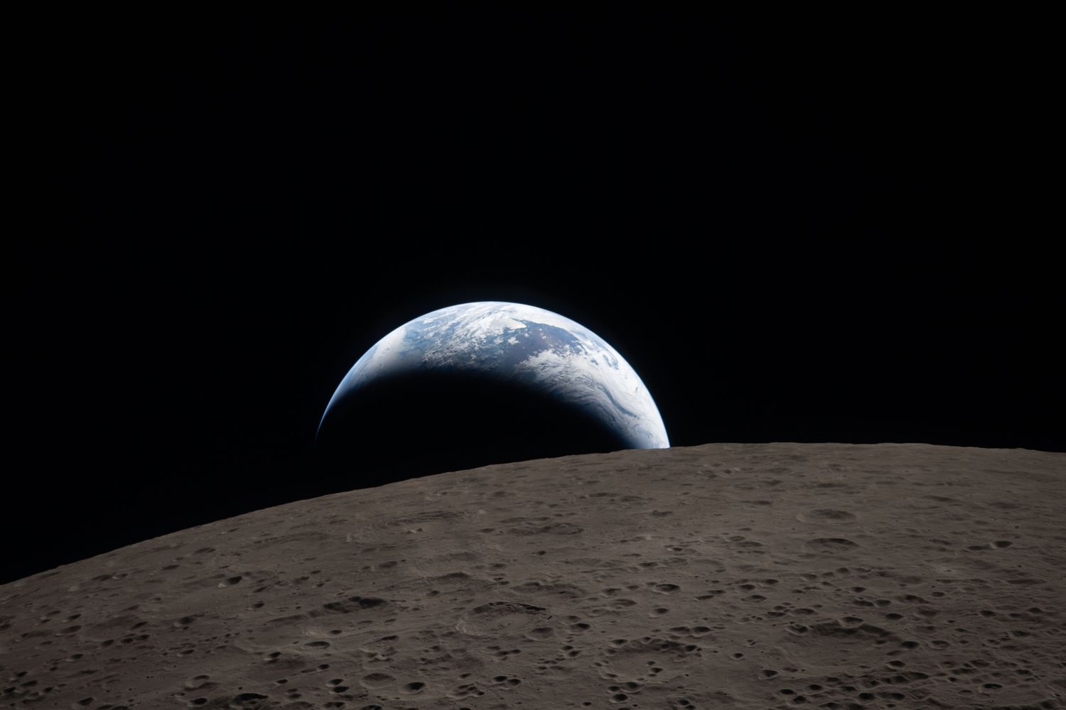View of Earth partially visible over the lunar horizon from space