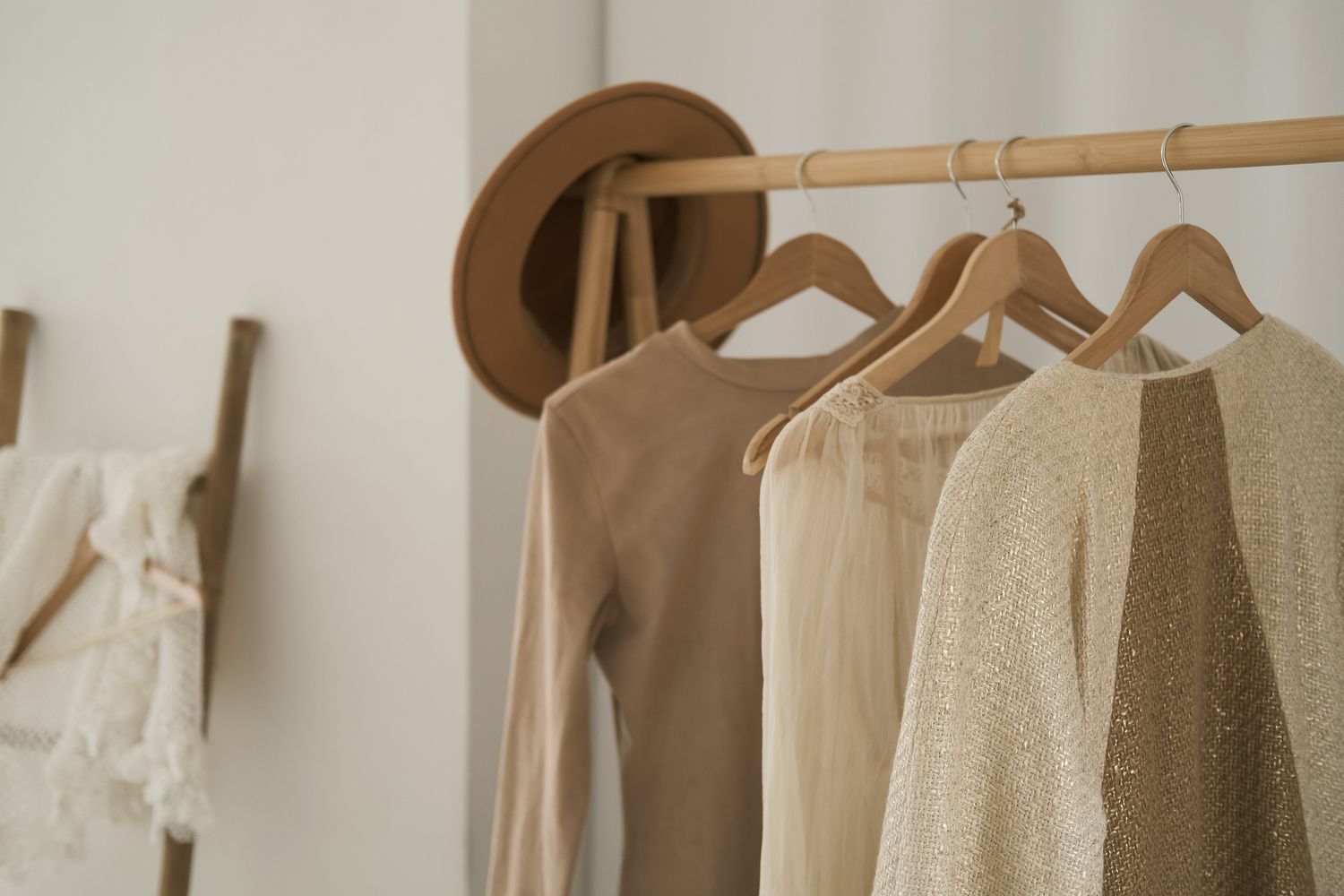 new clothing hanging on a rack in a bedroom