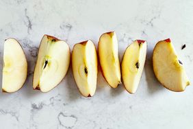 Sliced apple pieces arranged on a lightly textured surface