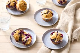 Plates with vegan blueberry muffins on a light table setting
