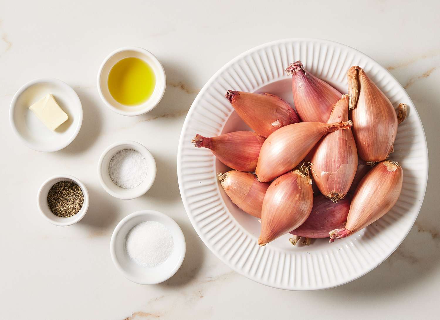 overhead view of bowl of shallots and small bowls of ingredients