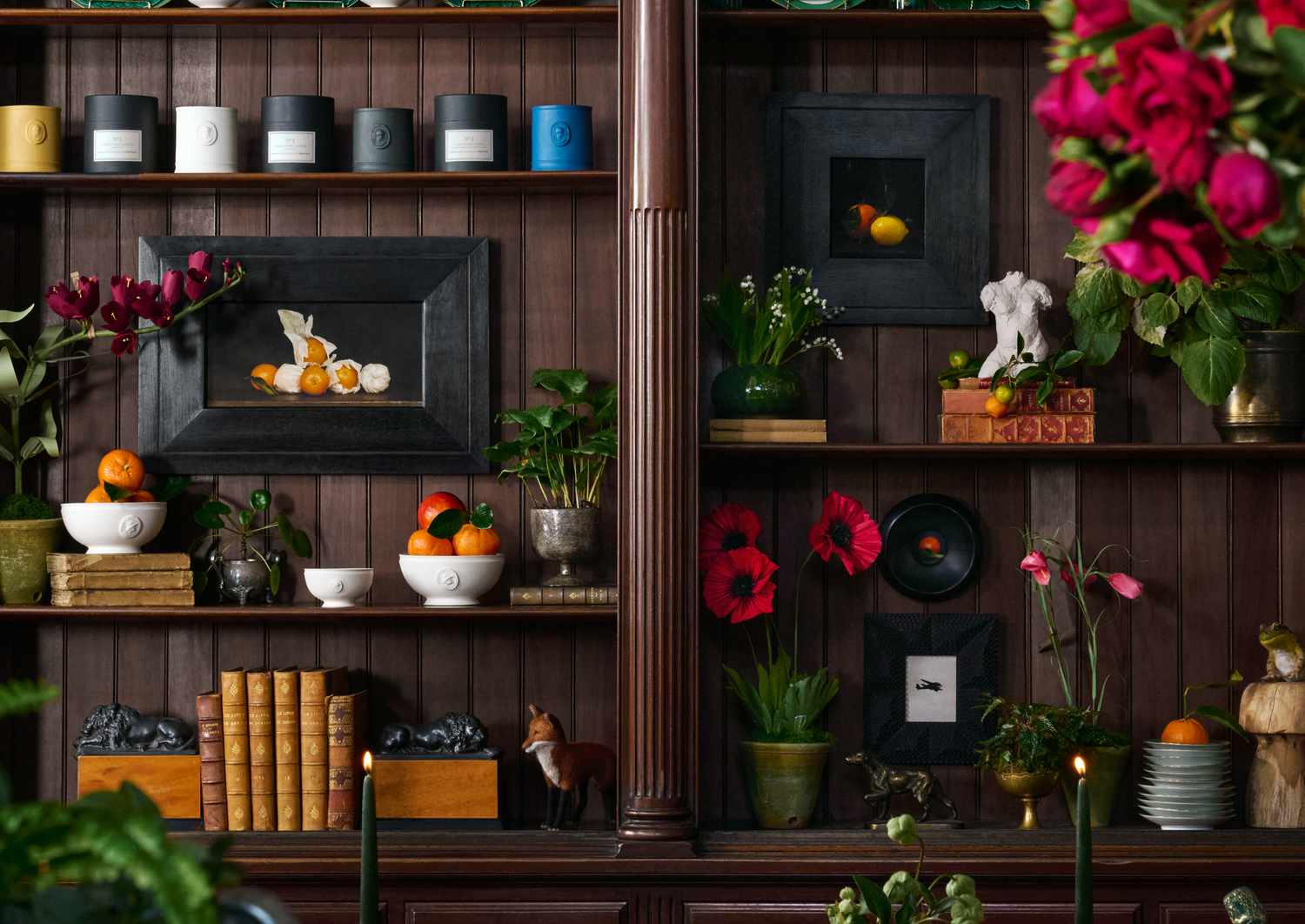 A shelf with candles and art