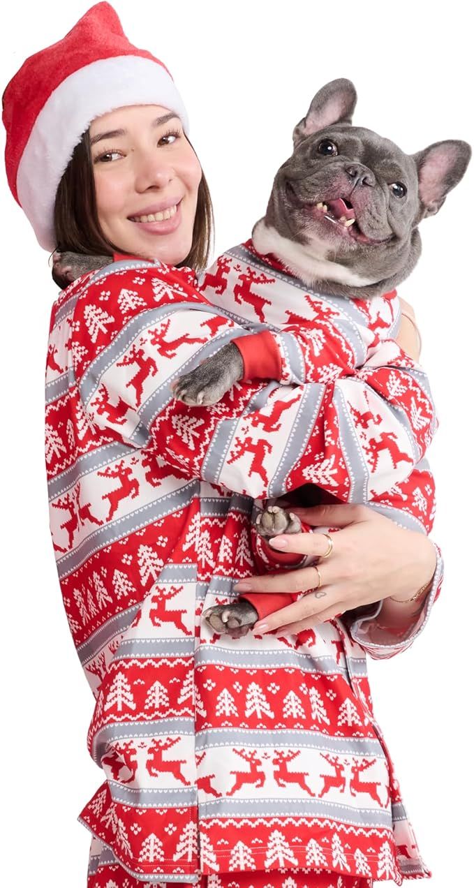 A person wearing a Santa hat holds a dog dressed in matching holidaythemed clothing
