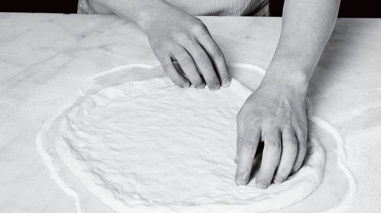 spreading out pizza dough