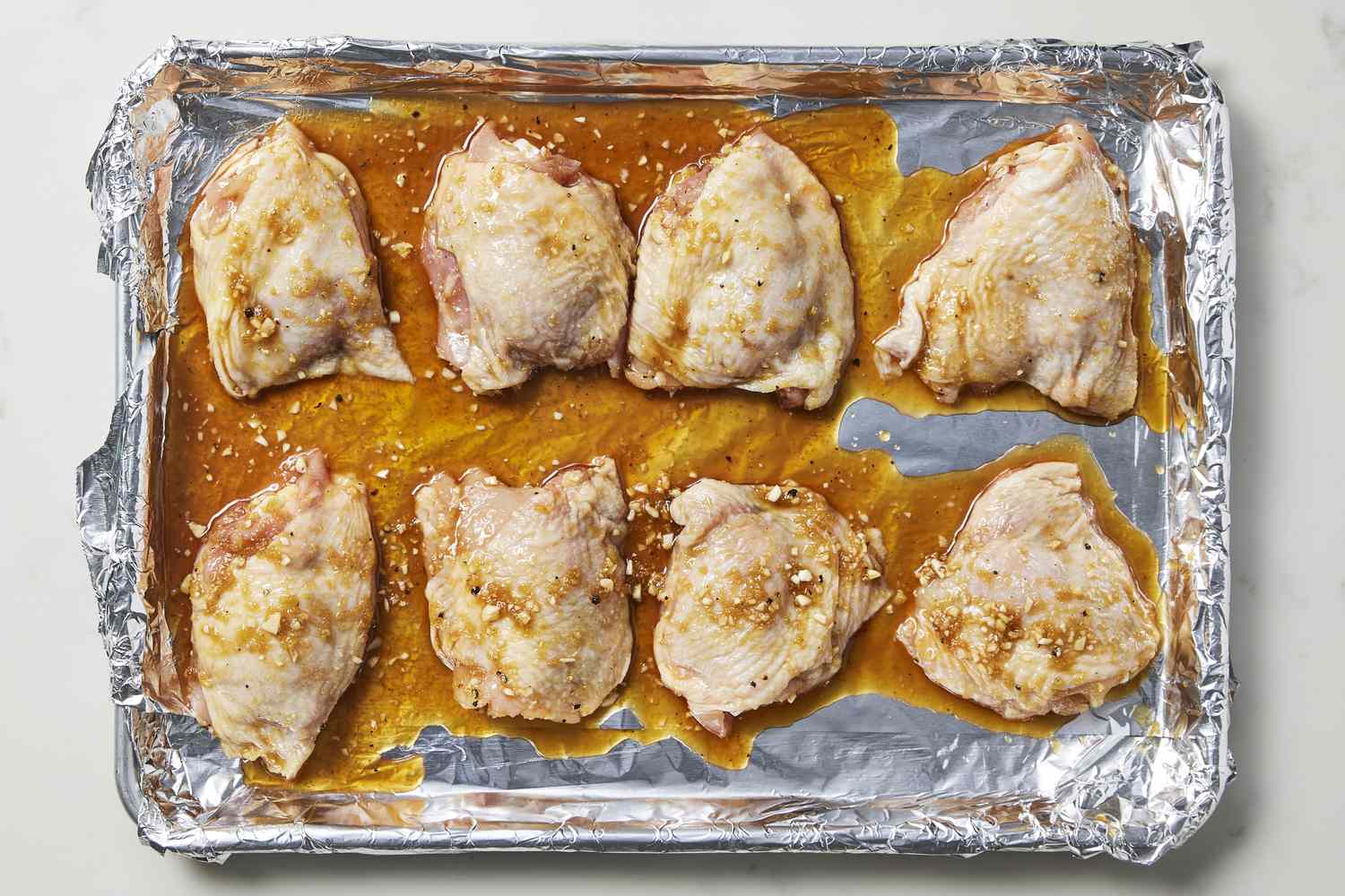 Chicken in teriyaki sauce on baking sheet