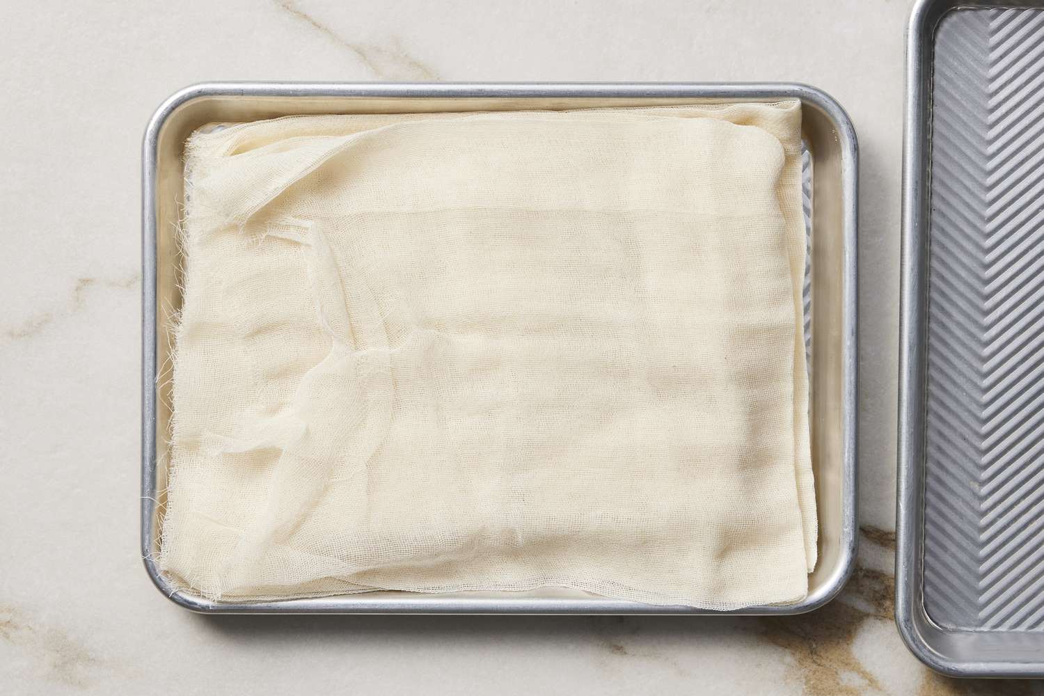 Tofu on baking sheet covered with paper towel