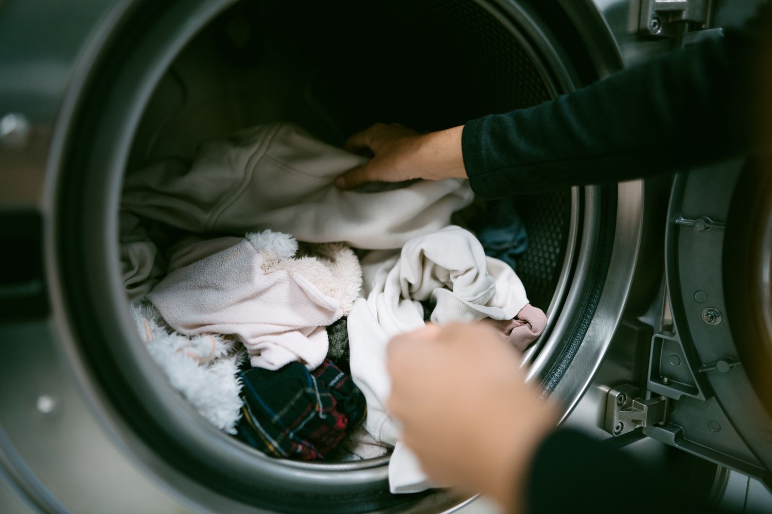 Person loading or unloading clothes from a frontloading washing machine