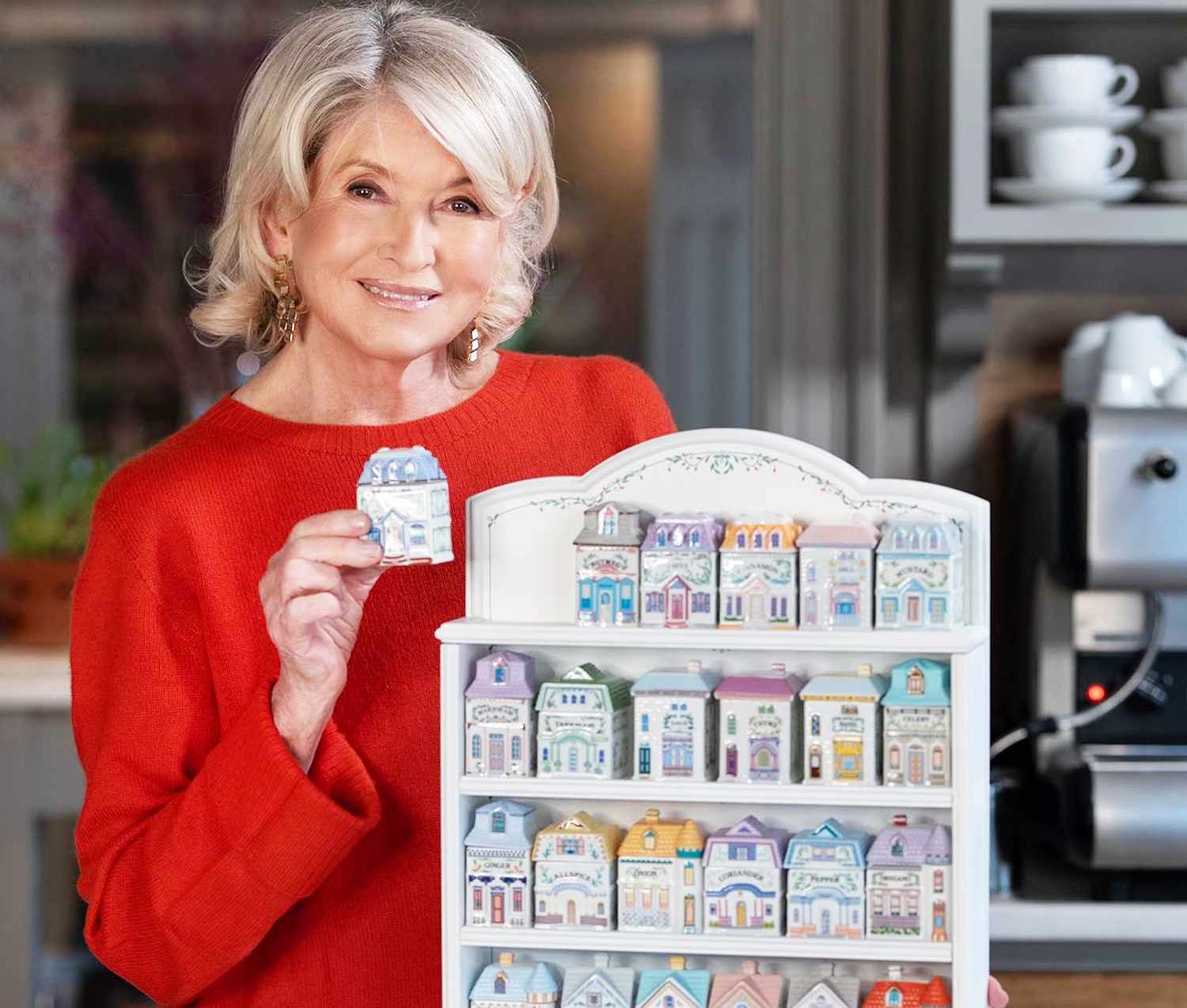 decorvow holding a small model house in front of a display of miniature house models